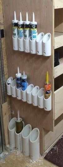 there are many cups on the wall and one is filled with glues, paint, and toothbrushes