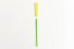 two green and yellow toothbrushes on a white surface