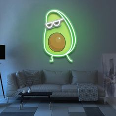 a living room with a couch and a neon sign on the wall that says avocado