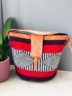 African Kenyan Handmade Traditional sisal tote kiondo handbag. Casual Beach bag Made from sisal Wool and leather handles. The bags are durable And unique. 100% made in Kenya. Measuring about 45  cm wide x 30cm deep. The tote bag is lined inside with black lining. Red Handwoven Crochet Travel Bag, Traditional Pouch Bag For Vacation, Red Shoulder Bag With Leather Handles For Market, Handwoven Pouch Bucket Bag For Travel, Red Handwoven Satchel Bag, Artisan Basket Bag For Travel, Handmade Red Straw Bag For Travel, Red Crochet Travel Bag, Handwoven Bucket Shoulder Bag As Gift