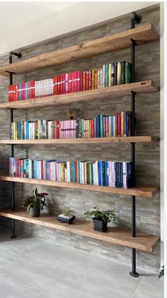 a bookshelf filled with lots of books next to a wall mounted planter