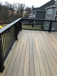 a wooden deck with black rails and railings