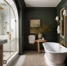 a bathroom with green walls and white bathtub