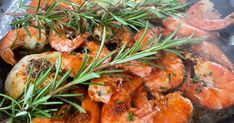 shrimp and carrots cooking in a skillet with rosemary sprigs on top