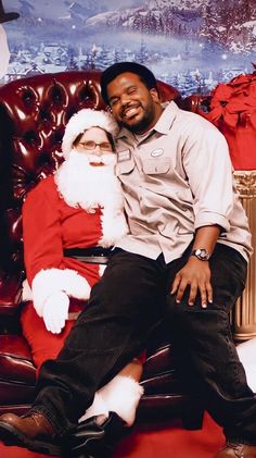 a man sitting next to a woman on top of a couch in front of a christmas tree