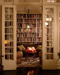 a living room filled with lots of books and furniture