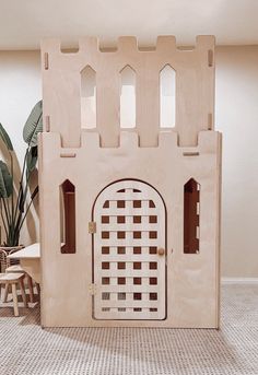 a wooden toy castle with windows and doors