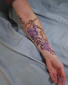 a woman's arm with purple flowers on it