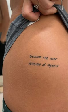 someone is writing on the back of a woman's body with words written in black ink