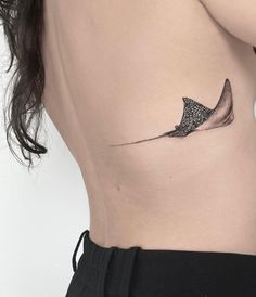 a woman's lower back with a tattoo on her left side, and an image of a fish in the water