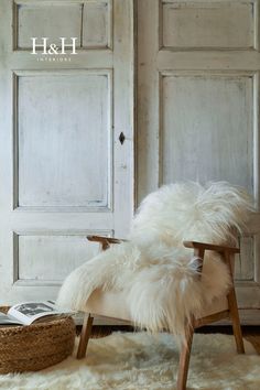 a white chair sitting on top of a rug in front of a wooden paneled door