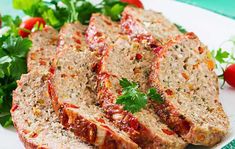 slices of meatloaf on a plate with parsley and tomatoes in the background