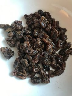 raisins in a white bowl on a table