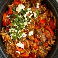 a bowl filled with rice and vegetables on top of a white table next to bread