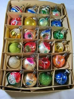 an open cardboard box filled with assorted christmas ornaments