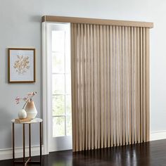 a living room with white walls and wooden blinds