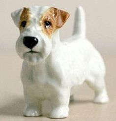 a small white and brown dog figurine on a table