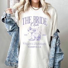 a woman wearing a t - shirt that says the bride club and has a drink in it