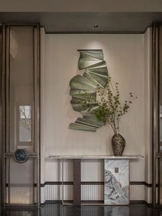 a vase with some plants in it sitting on a table next to an entrance way