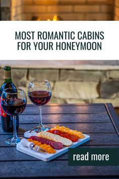 two glasses of wine and a plate of food on a table with the words most romantic cabins for your honeymoon