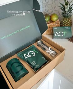 an open box containing the ag products and pineapples next to it on a counter