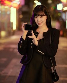 a young woman is holding up her cell phone