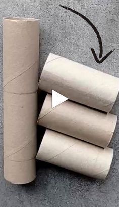 three rolls of toilet paper sitting on the ground next to each other with an arrow pointing up