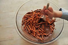 a person is spreading chocolate on top of some pretzels