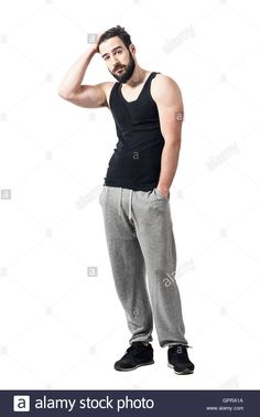 a man in black tank top and grey sweatpants standing with his hand on his head