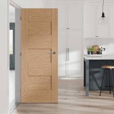 an open door in a kitchen with stools next to the counter and sink area