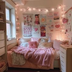 a bedroom with lights strung from the ceiling and pictures on the wall above the bed