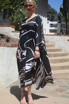 Striking black and white designer print silk caftan is a caftan that will take you from casual to dressy for any occasion.  With it's  modern, abstract design, it is a smart choice.   One size.  Fits many sizes small to X-large.  It measures 52 inches from edge to edge, 104 inches around the body.  The side seams are 6 inches from the edge giving 80 inches around the body and a beautiful, flowing look.  The length is 51 inches.  Machine wash on a short, delicate cycle or hand wash. Chic Black Maxi Dress With Abstract Print, Chic Black V-neck Kaftan, Black Abstract Print Dress For Vacation, Black Maxi Dress With Abstract Print, Black Dress With Abstract Print For Vacation, Black Beach Dress With Abstract Print, Casual Black Kaftan With Kimono Sleeves, Black Printed V-neck Kaftan, Casual Black Maxi Kaftan