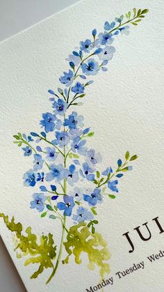 a card with blue flowers and the words july written in brown ink on white paper