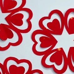 red paper hearts cut out on a white surface