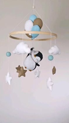 a baby mobile with a penguin and stars hanging from it's side in the air