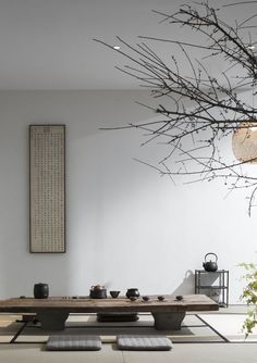 a room with a table and some plants in the corner next to it on top of rugs