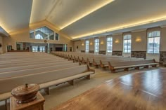 an empty church with rows of pews in the middle and wood floors on both sides