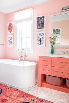 a bathroom with pink walls and an oval bathtub