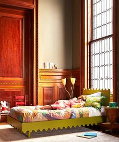 a child's bed in the corner of a room with wooden paneled walls