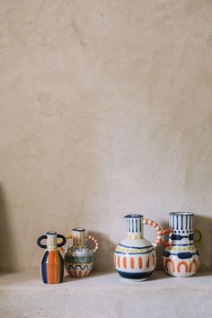 three vases are lined up on a shelf next to each other and one is empty