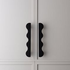 two black handles on white cabinets in a room