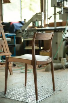 a wooden chair sitting on top of a metal floor