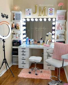 a room with a vanity, chair and mirror in it that has lights on the wall