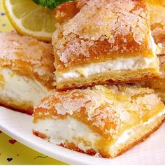 several pieces of cake on a plate with lemon wedges and mint sprig