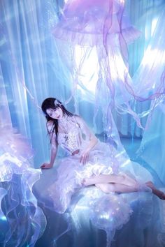 a woman sitting on top of a bed covered in jellyfish