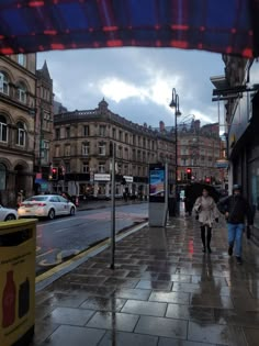 two people walking down the street in the rain