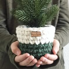 a person holding a potted plant in their hands with a name tag on it