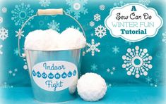 a bucket filled with snow sitting next to two balls of white cotton on top of a blue background