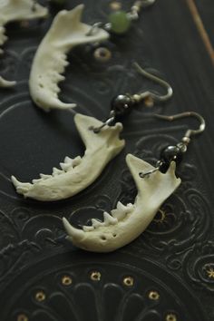 Real bone and hematite stone earrings: Real hand-drilled weasel jaw bones paired with beautiful hematite beads, mounted on hook clasps. A unique pair of earrings, very original which will appeal to fans of natural history or cabinets of curiosities and taxidermy. These jewels are made of organic material, so each model differs and may vary slightly in terms of shape and size from the photo. Natural Earrings, Goblin Jewelry, Bone Accessories, Viking Earrings, Bone Jewelry Necklaces, Animal Bone Jewelry Clay, Bone Earrings Handmade, Vertebrae Earrings, Animal Bones Jewelry