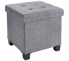 a grey ottoman with buttons on the top and legs, in front of a white background